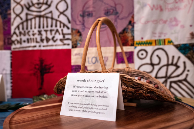 A notecard with text reading "words about grief" next to a basket invites people to share.