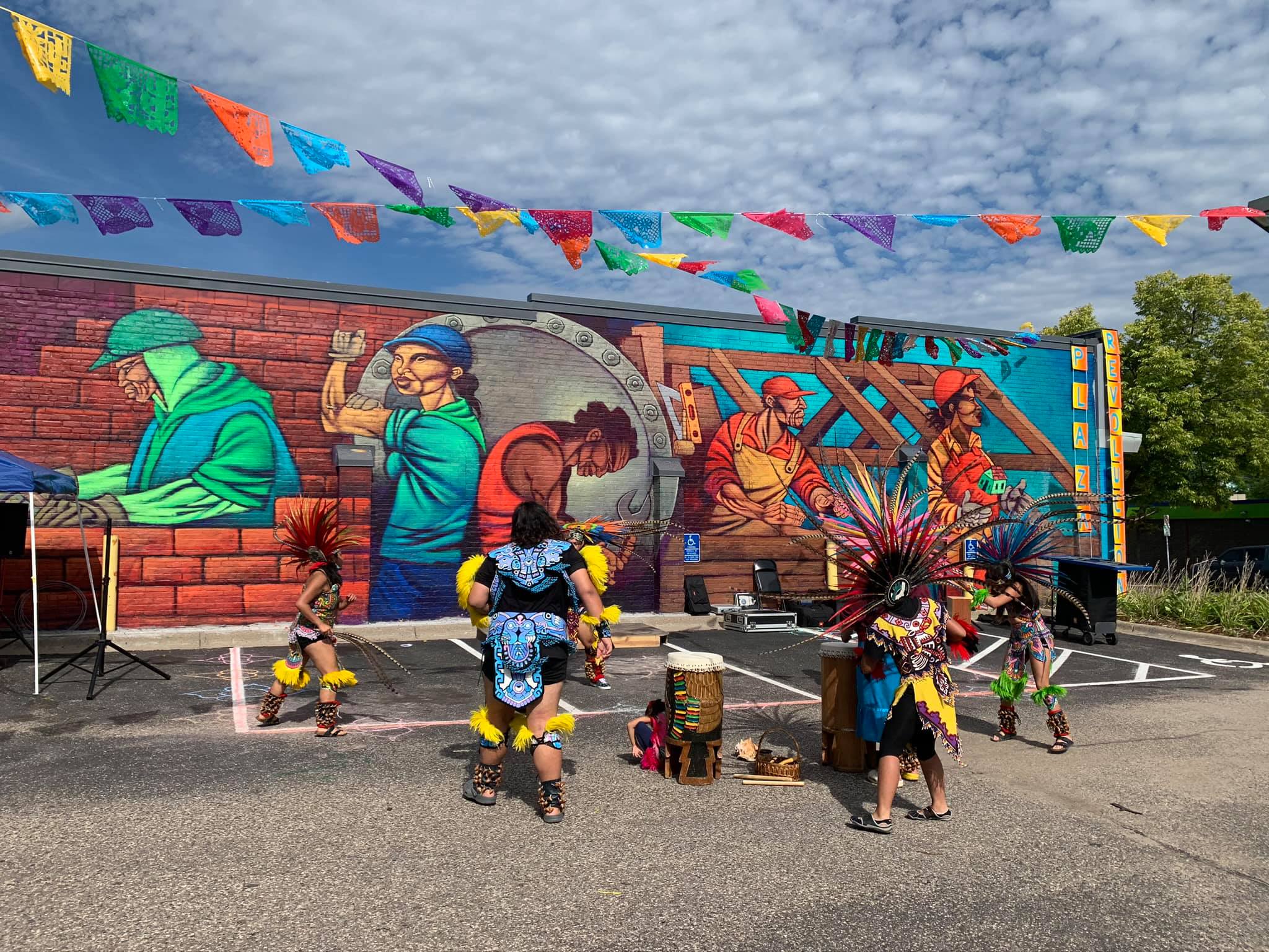 A group of performers move in a circle around a pair of drums.