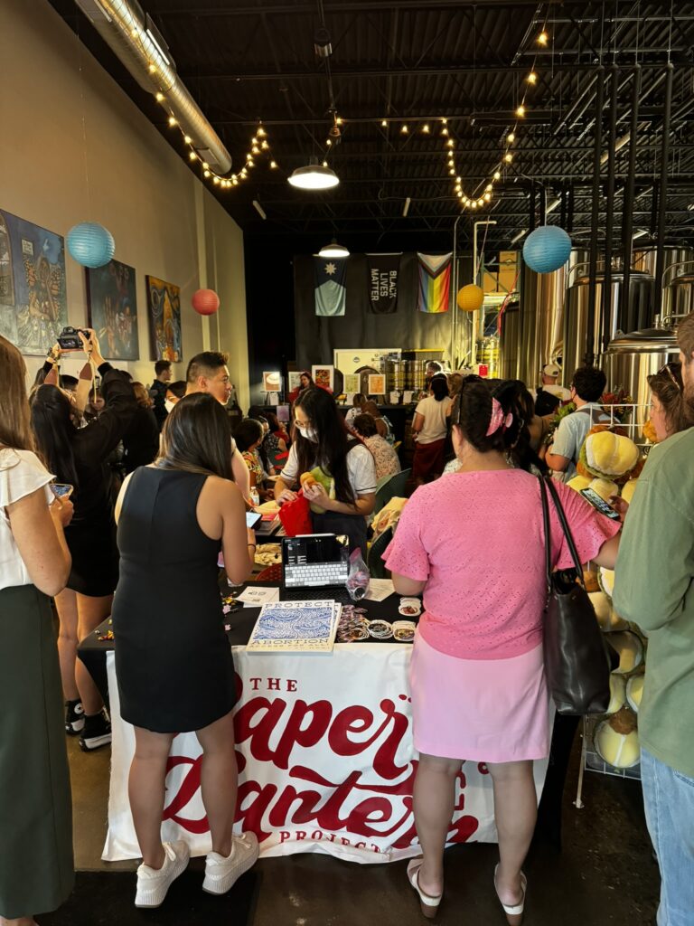 A crowd of people in a brewery space.