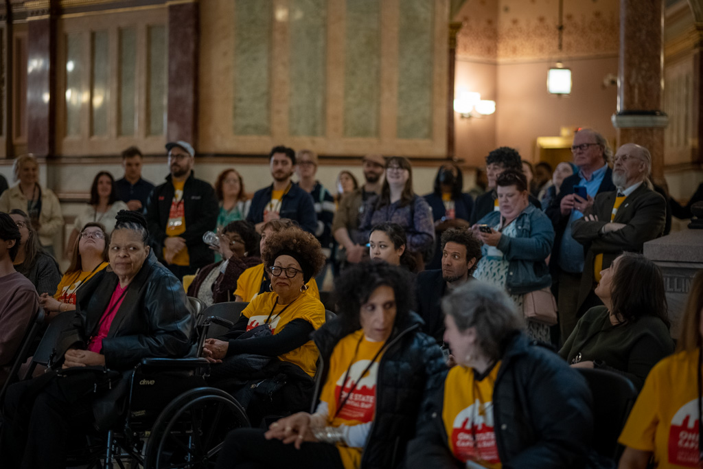 A group of people in colorful t-shirts in a formal governmental building.
