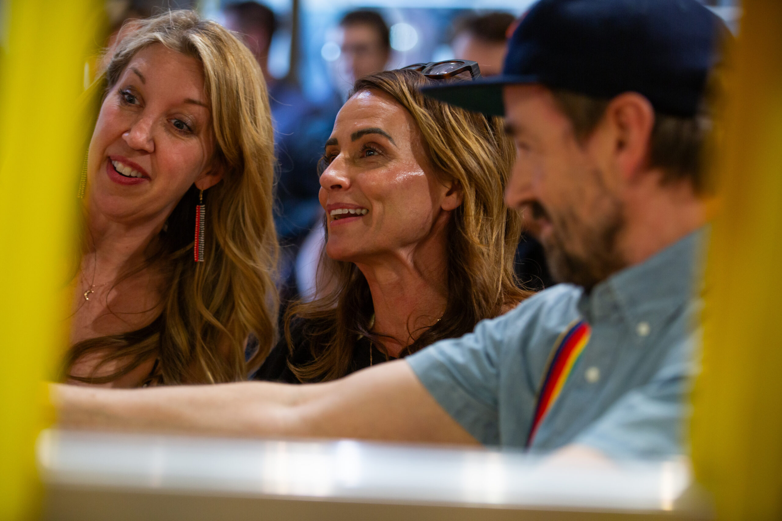 Three people stand next to each other as they look at something off frame.