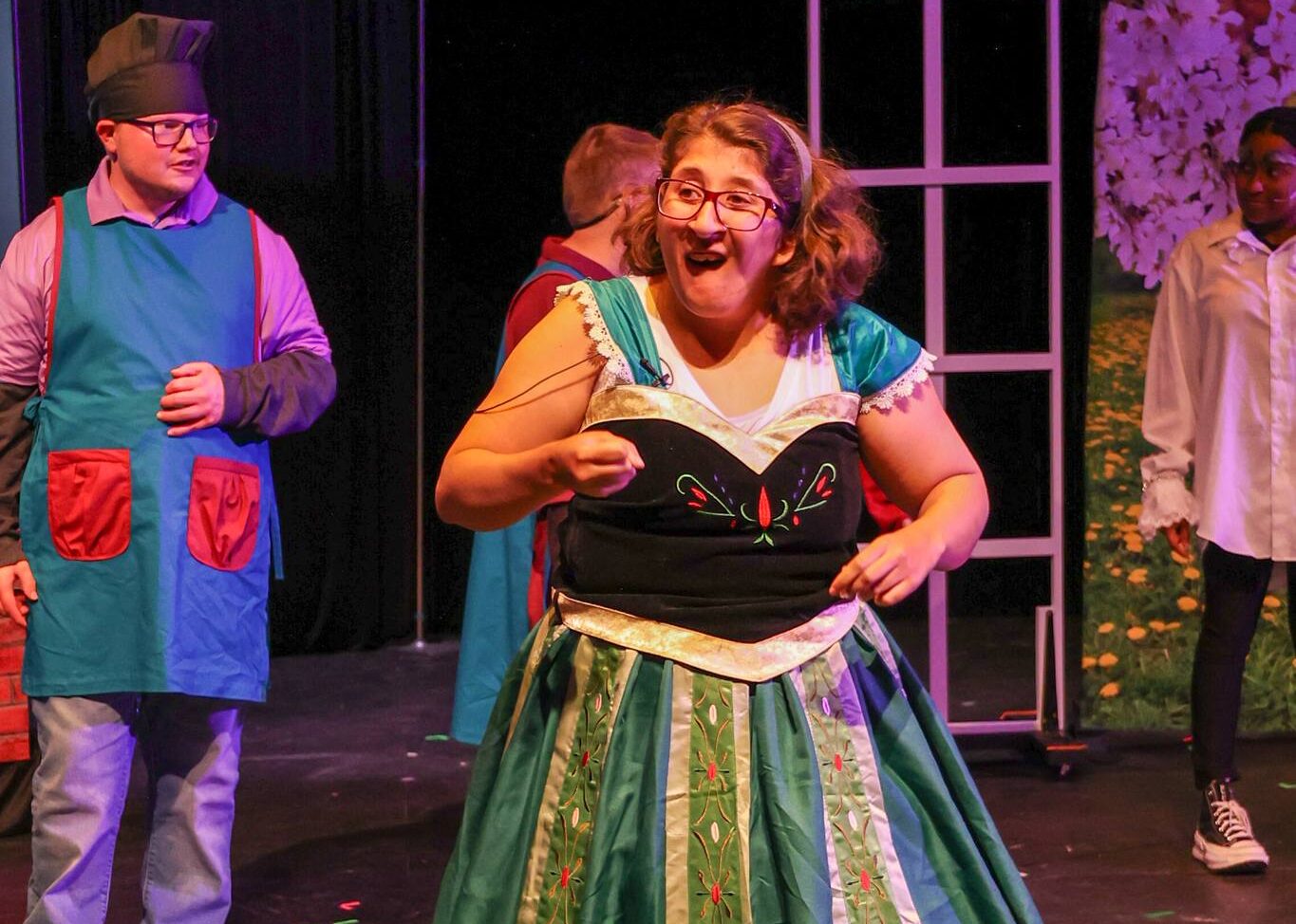 People perform on stage wearing costumes.