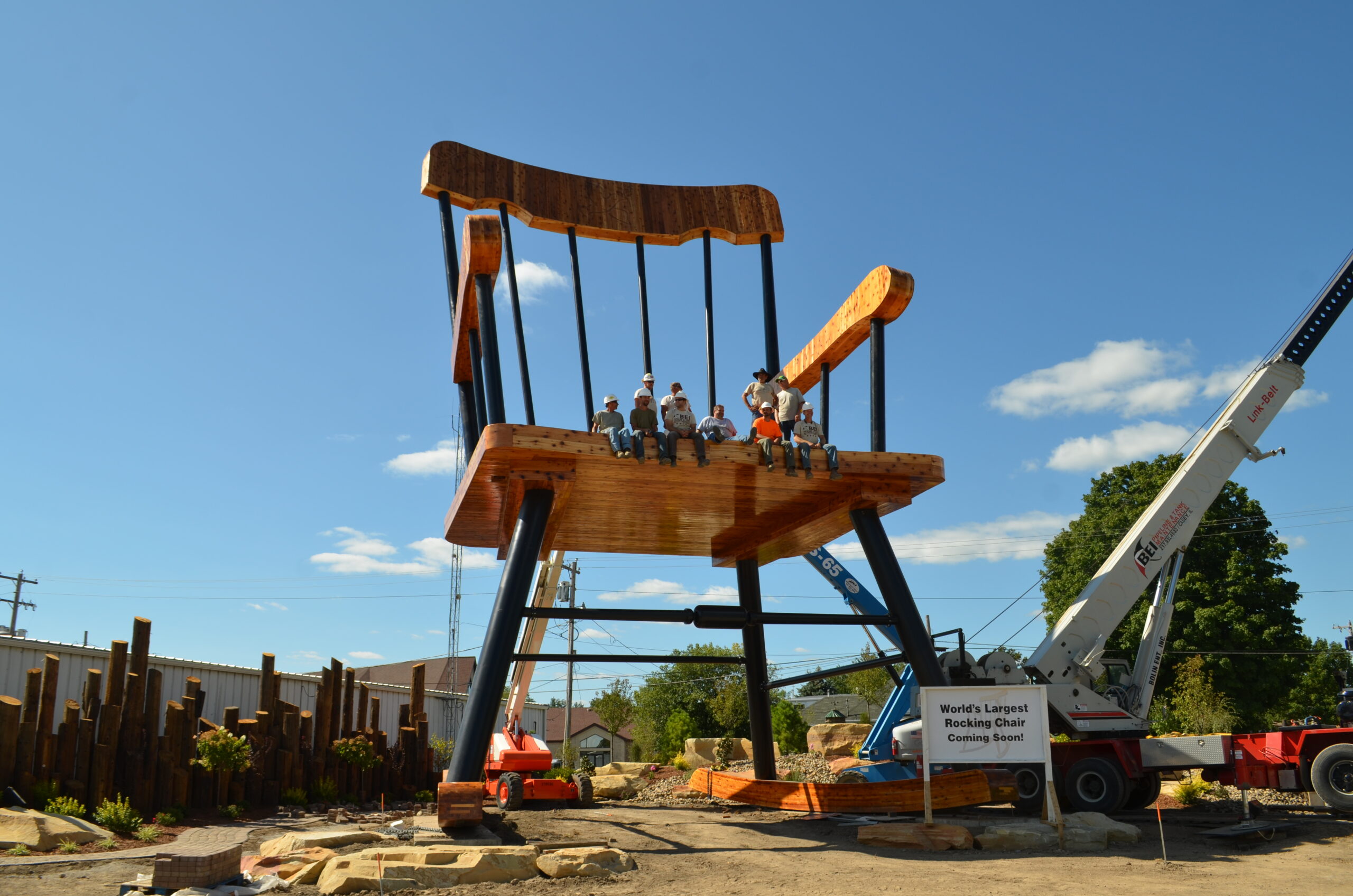 People sit on a large rocking chair.