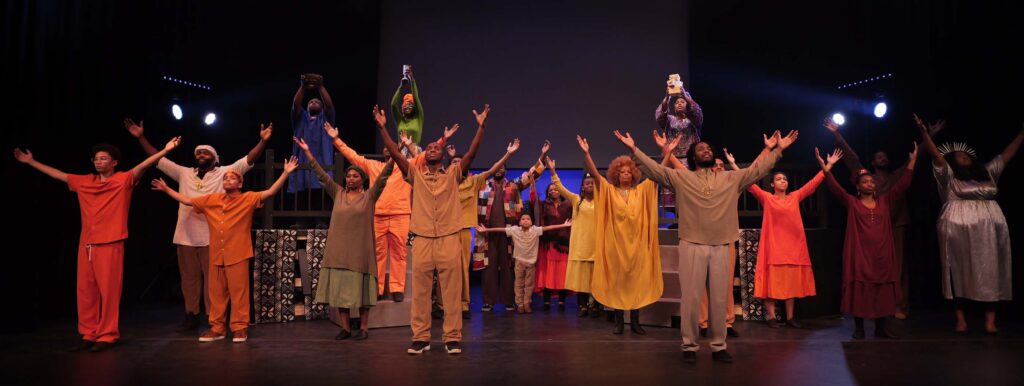 Performance shot featuring actors with arms raised