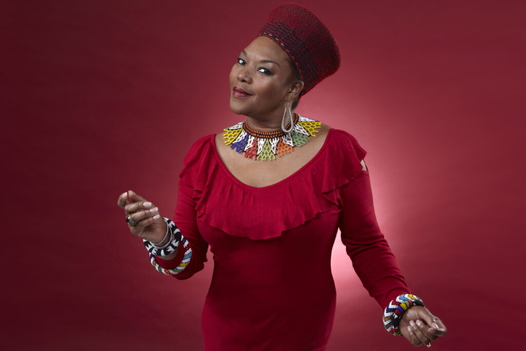 Lorraine Klassen, an artist from South Africa who specializes in Township Music, poses for a photo and appears to be dancing.